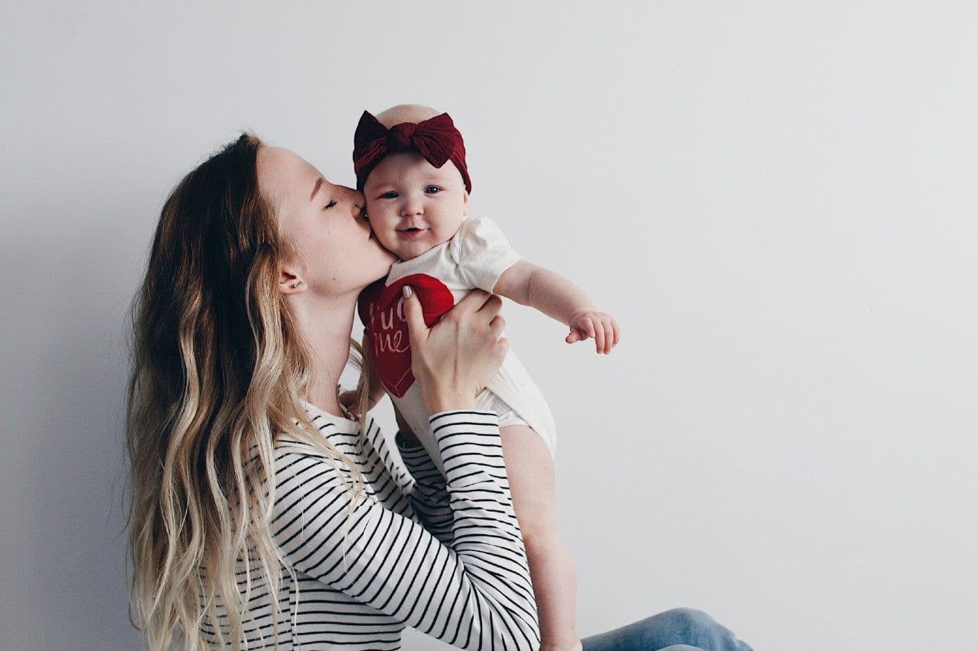Mum gives baby girl a smooch on the cheek
