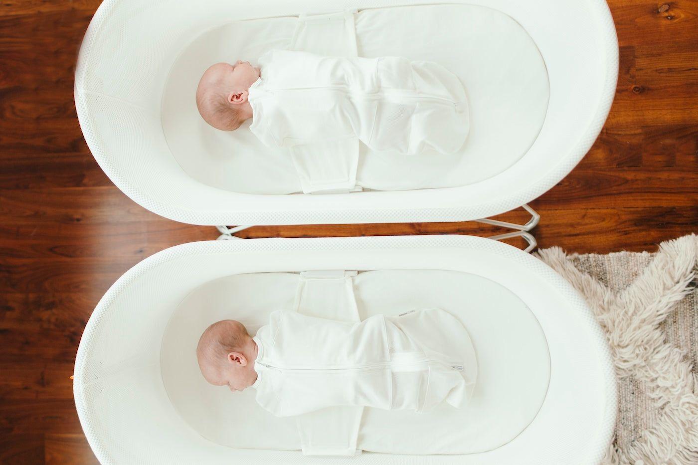 Twin babies sleeping in two SNOO Smart Sleepers