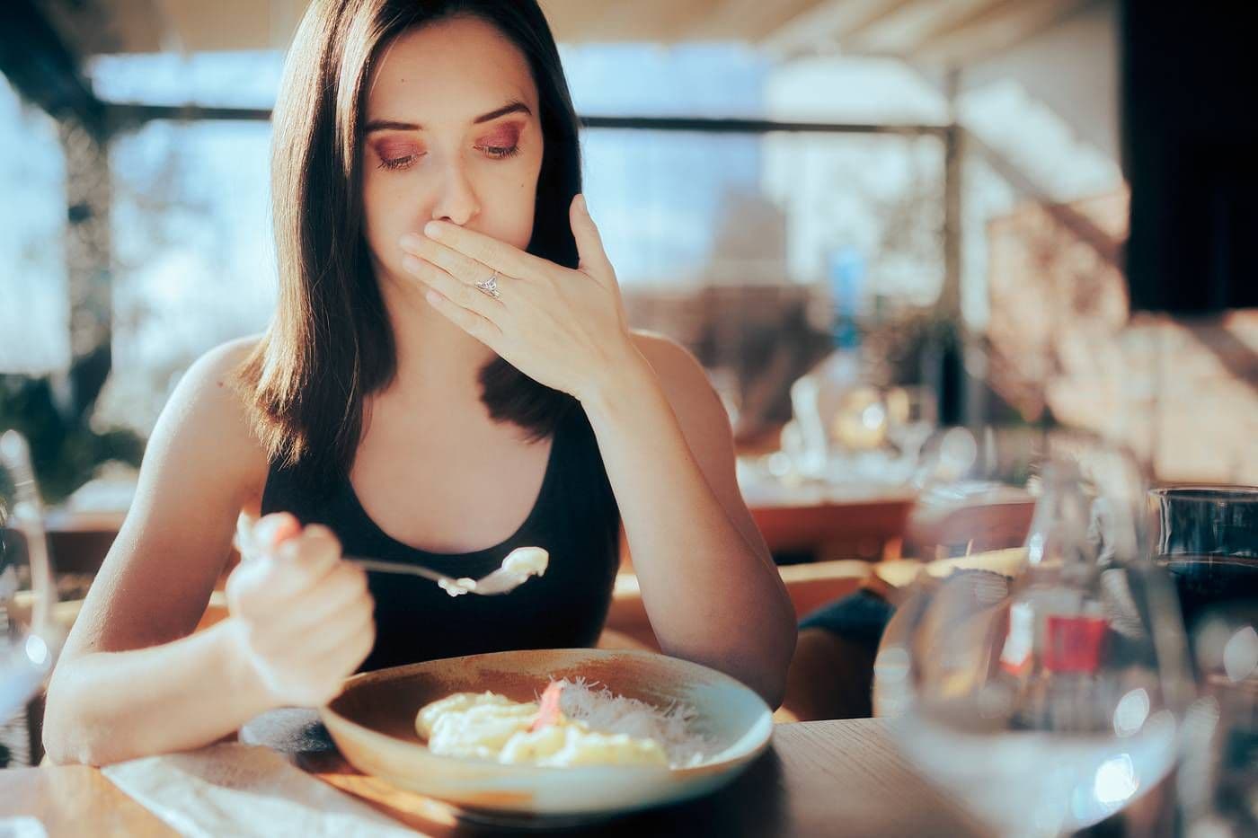A woman is nauseated by her meal