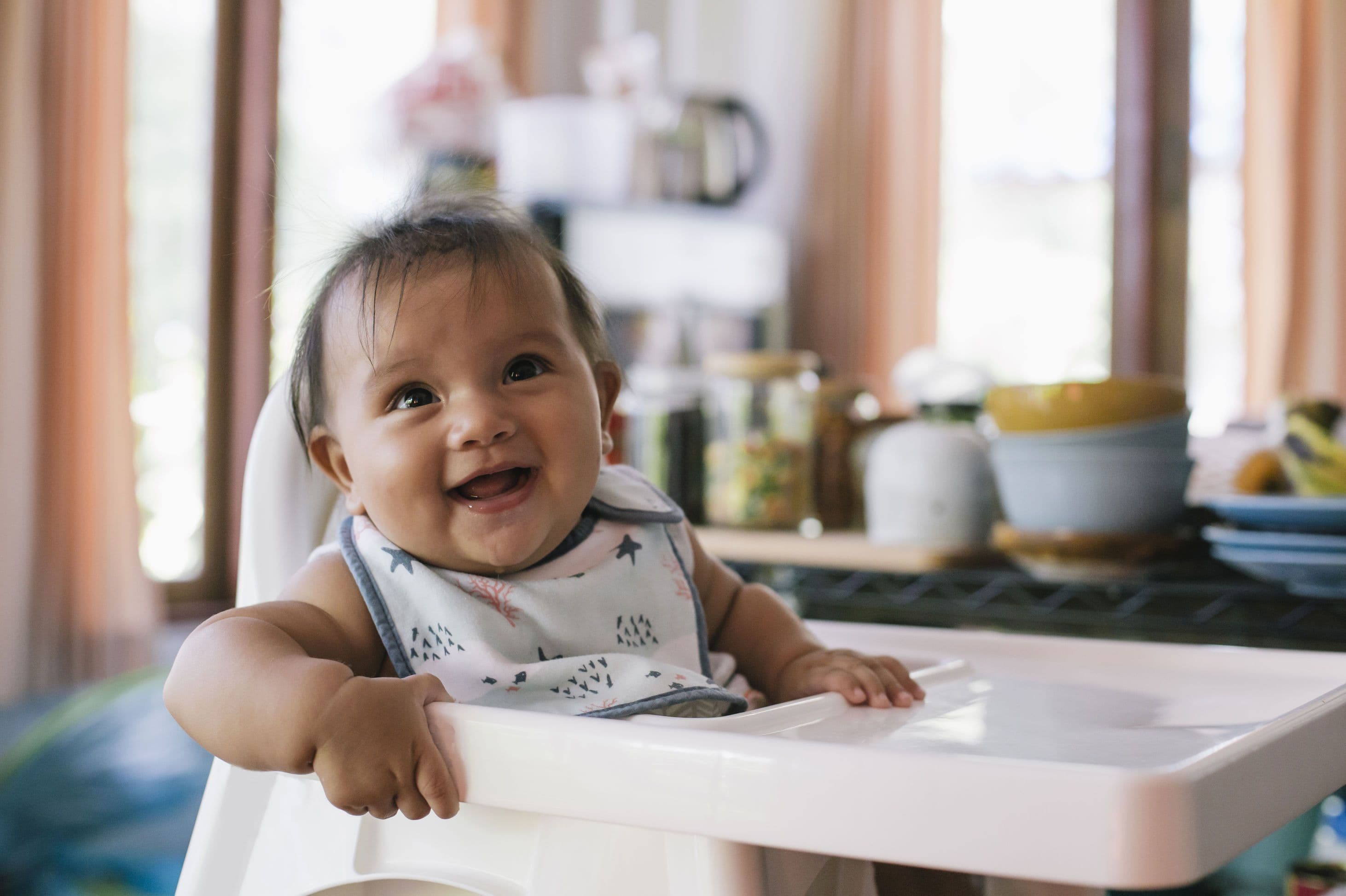 Smiling baby sitting in a feeding chair
